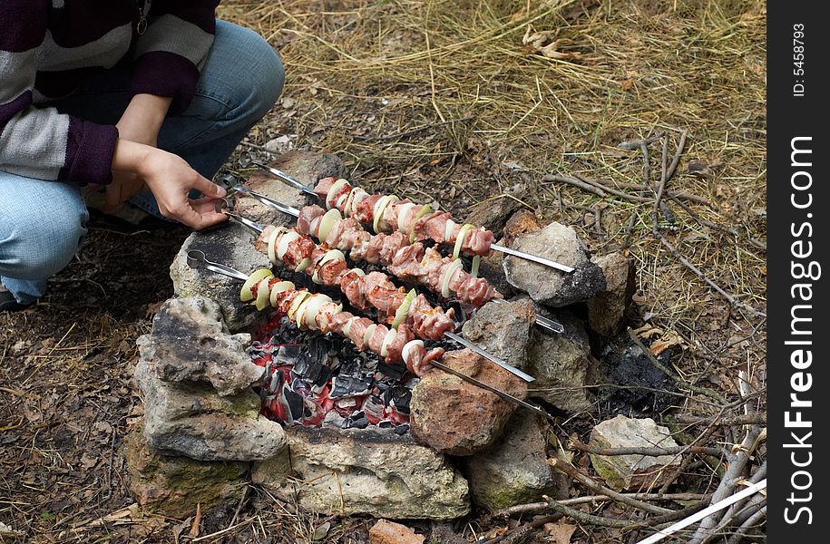 Preparing kebab at outdoors picnic using natural stone fireplace. Preparing kebab at outdoors picnic using natural stone fireplace