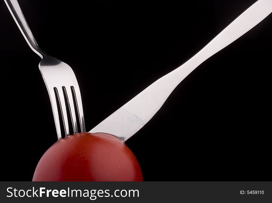 Knife with forks help slices juicy  tomato. Knife with forks help slices juicy  tomato.