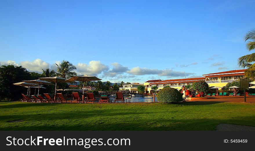 A beautiful resort in yellow with nice flowers in the garden.