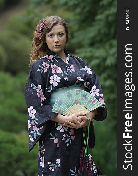 Portrait of girl dressed in yukata (traditional Japanese dress) and holding the fan. Portrait of girl dressed in yukata (traditional Japanese dress) and holding the fan