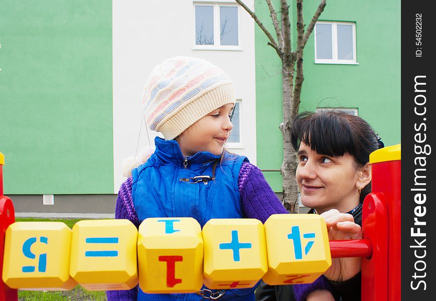 Mom teaches daughter to be considered with wooden cubes