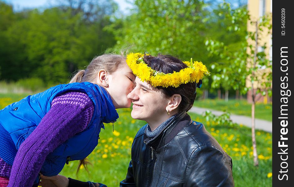 Daughter kisses mom in the park