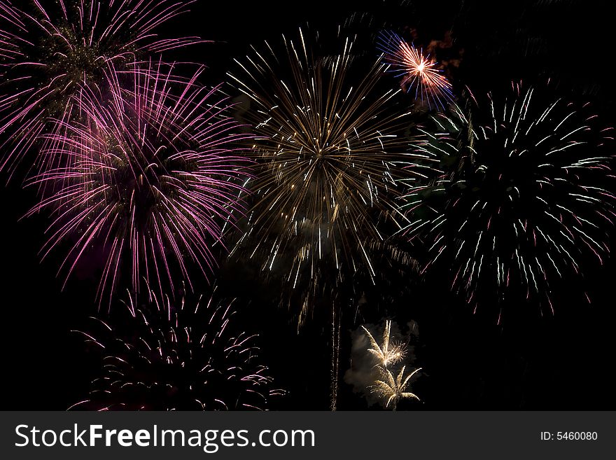 Fireworks display with several different colored fireworks exploding in the sky.