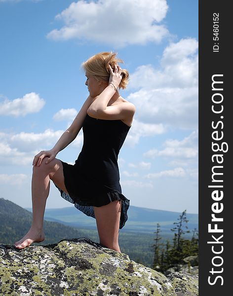 Woman in the black dress on rock