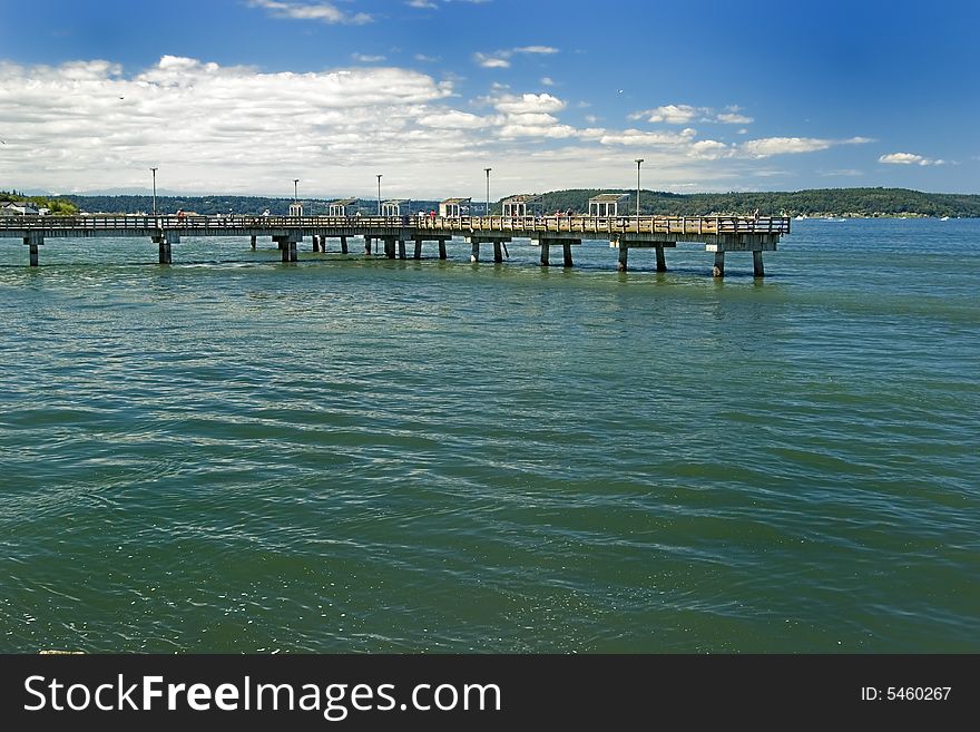 A long pier over the coean with blue skies. A long pier over the coean with blue skies