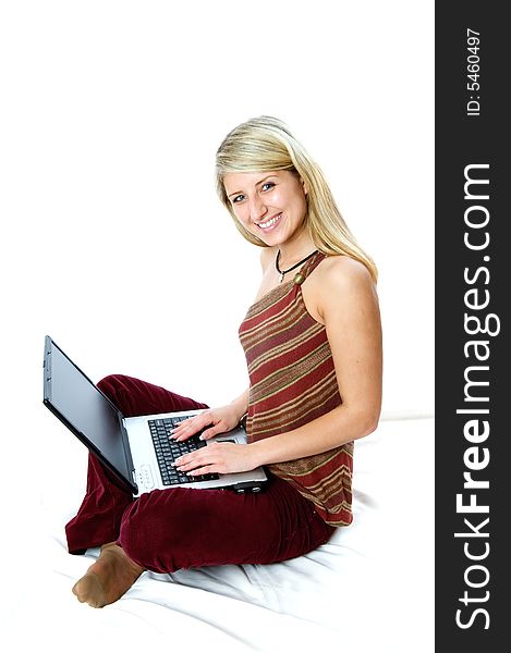 Beautiful girl with blonde hair using a laptop computer and smile. Shot with Nikon D3. Beautiful girl with blonde hair using a laptop computer and smile. Shot with Nikon D3.