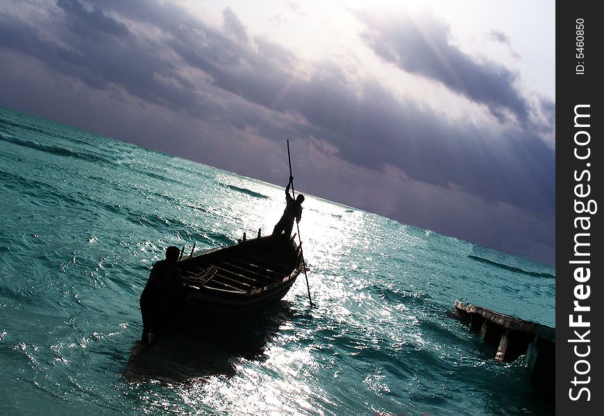 A single fisherman rowing his boat in the sea for fishing. A single fisherman rowing his boat in the sea for fishing