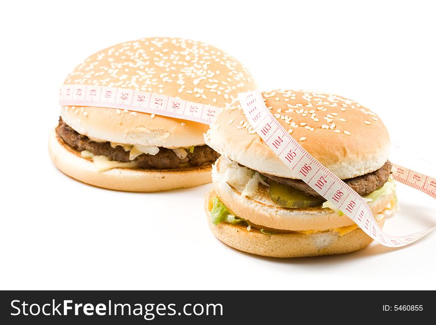 Bread with fried meat, cheese, onion, lettuce and measuring tape isolated on a white background. Bread with fried meat, cheese, onion, lettuce and measuring tape isolated on a white background.