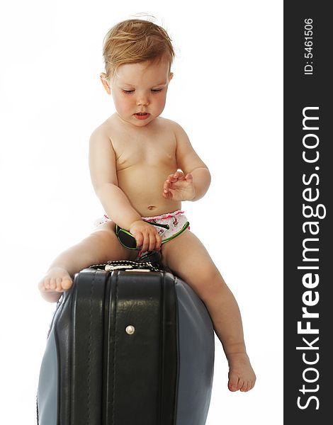 A baby with goggles sitting on a valise. A baby with goggles sitting on a valise