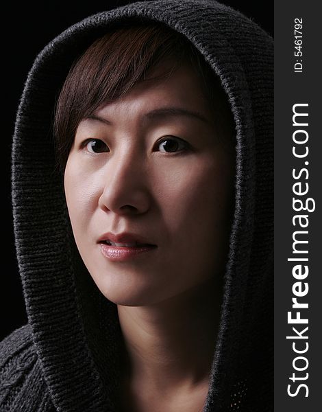 Asian Woman In Deep Thoughts - Hood Over Head - Black Background. Asian Woman In Deep Thoughts - Hood Over Head - Black Background