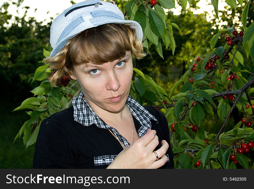 The young girl collects a sweet cherry