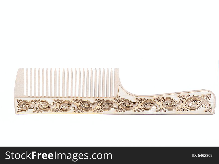 A wooden pattern comb on a white background. A wooden pattern comb on a white background