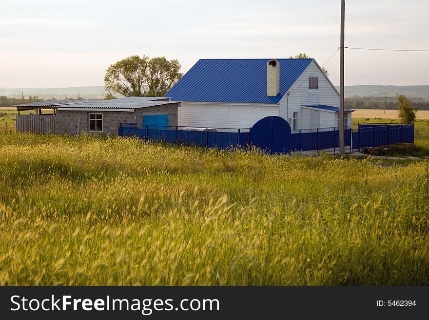 Small house in village with a dark blue roof