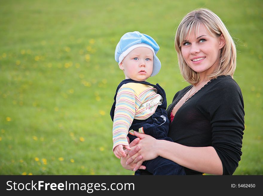 Mother hold baby on grass background