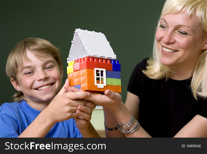 The woman and the boy hold a toy small house