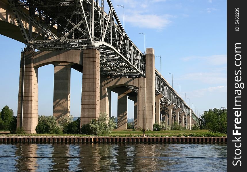 A steel bridge on concrete supports over the pier and canal. A steel bridge on concrete supports over the pier and canal.