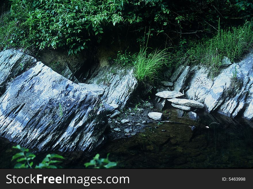 Stream with several rocks on the stream bank. Stream with several rocks on the stream bank.