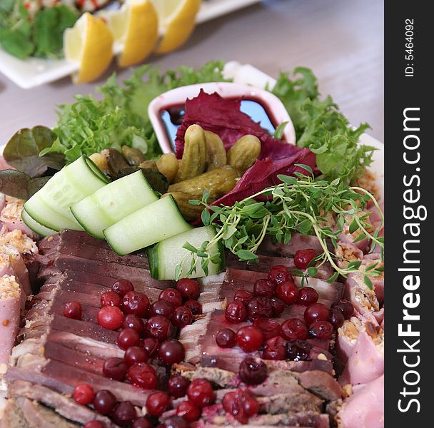 Meat plate with cucumbers and salad