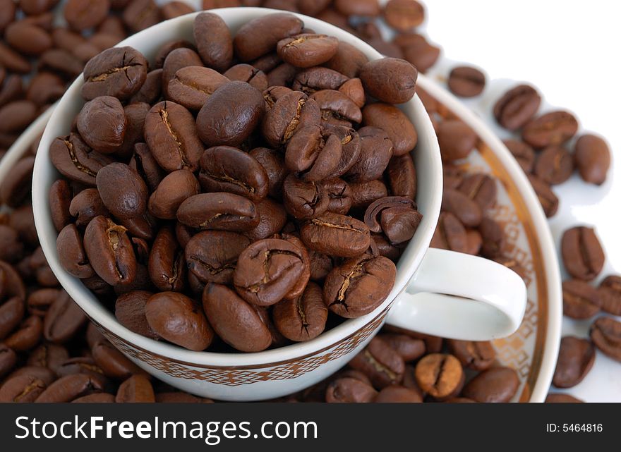 Heap of coffee beans with cap and saucer