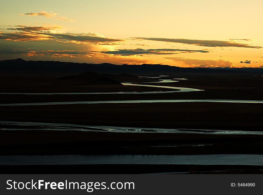 When travelling in Tibet of China in autumn,   headwaters Yellow River on the meadows appear in front of us, with sunset. When travelling in Tibet of China in autumn,   headwaters Yellow River on the meadows appear in front of us, with sunset.