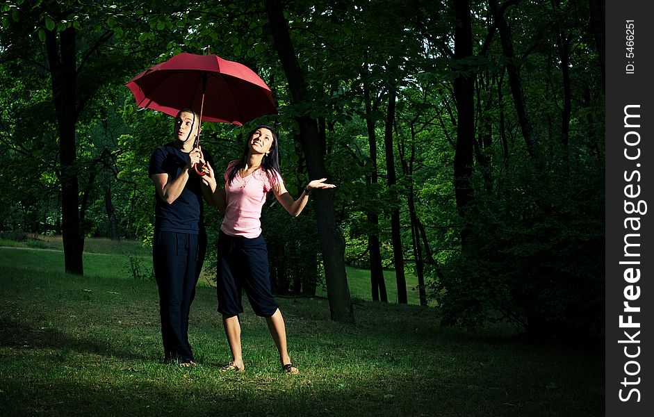 Young couple under red umbrella.