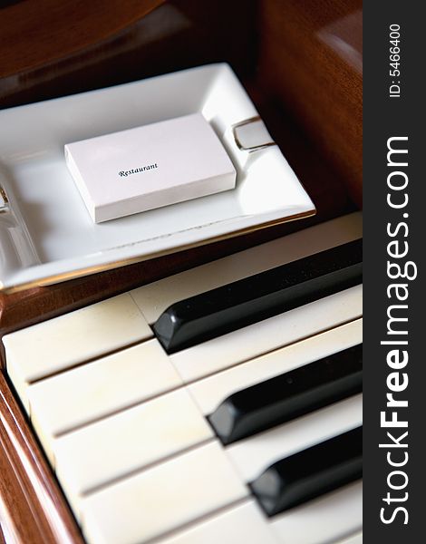 Ashtray,box of matches and Piano keyboard close up look. Ashtray,box of matches and Piano keyboard close up look