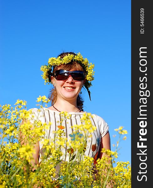 Beautiful girl and yellow flowers over a blue sky