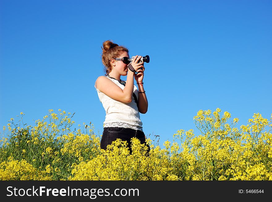 Beautiful girl with camera over a blue sky
