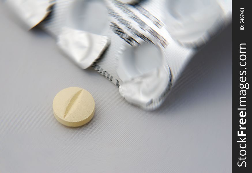 Yellow tablet with foil wrapping and blur effect. Yellow tablet with foil wrapping and blur effect