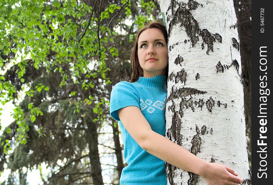 The young girl stands up for a birch. The young girl stands up for a birch