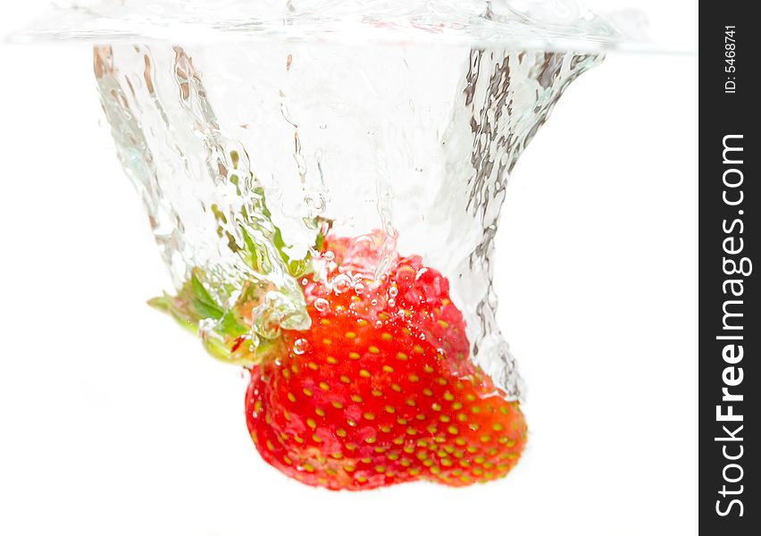 Close-up splashing strawberry, isolated on white