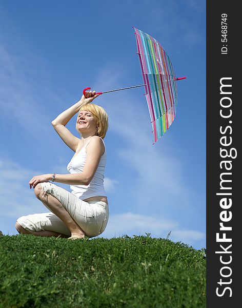 Young charming girl with umbrella against blue sky