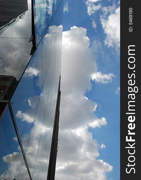 Glass building wall with clouds