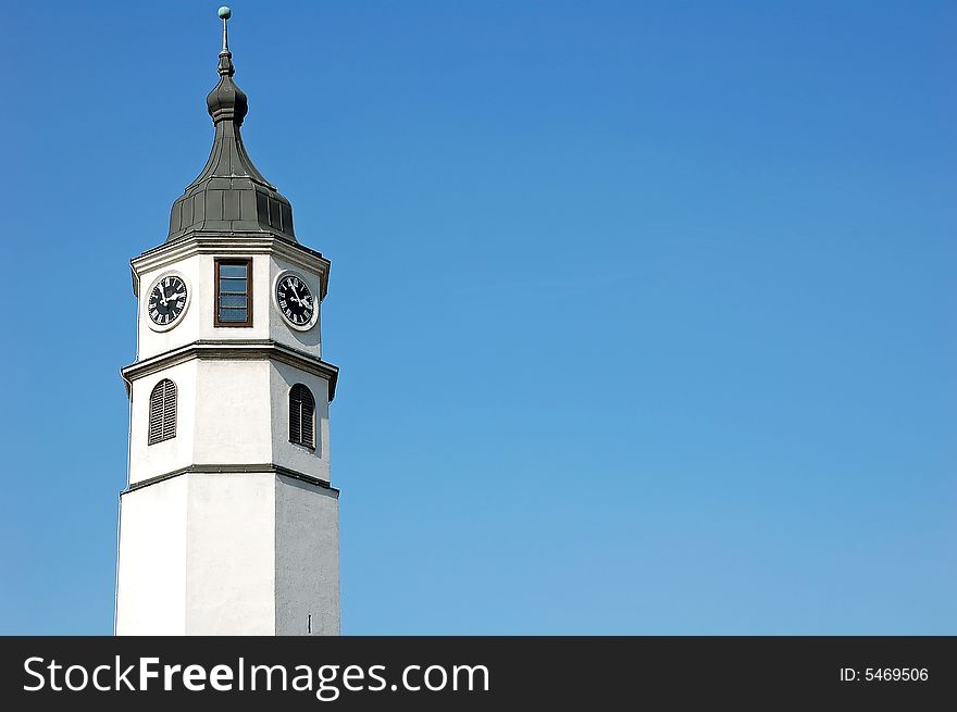 White tall clock tower against blue sky