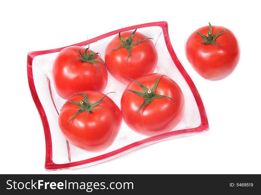 Red tomatoes on a glass plate,isolated. Red tomatoes on a glass plate,isolated.