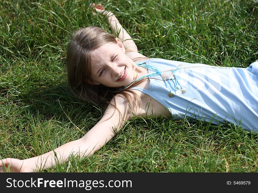 Young girl laying on the green grass