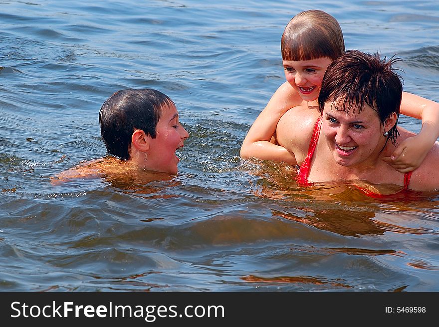 Mother and her two children having water fun. Mother and her two children having water fun