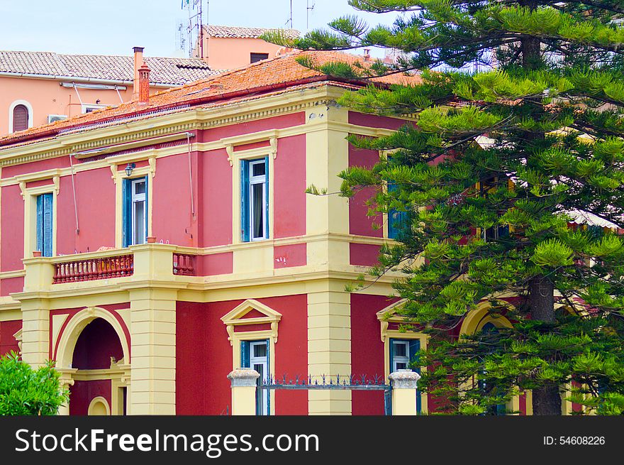 Red and cream colored Georgian style house with low balcony showing detail of windows and main entrance with archway. Red and cream colored Georgian style house with low balcony showing detail of windows and main entrance with archway.