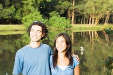 Smiling Couple In Front Of A Pond - Horizontal Stock Photos Smiling Couple In Front Of A Pond - Horizontal Stock Photos