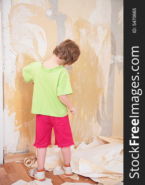 A little girl remove old wallpapers