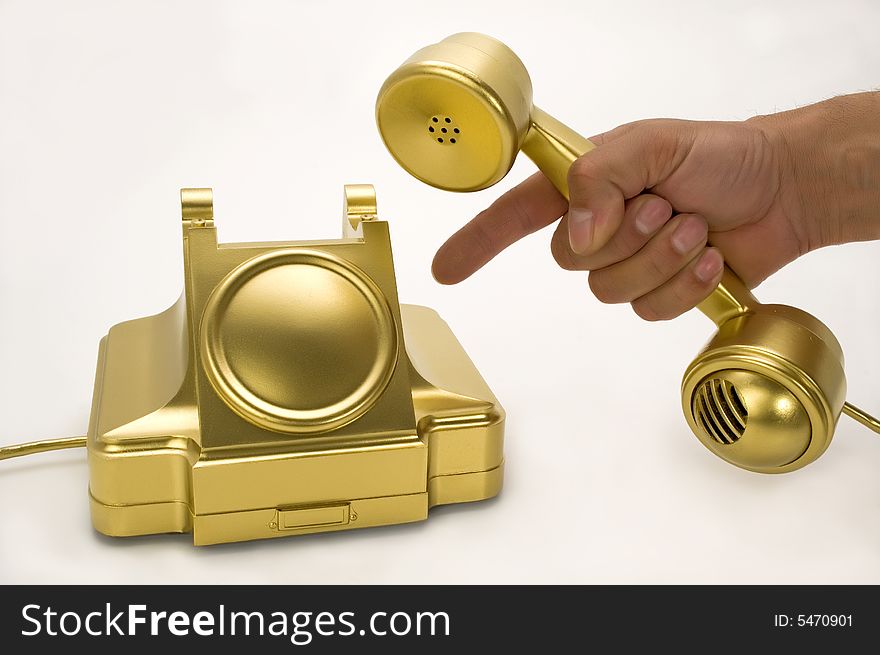 The telephone of gold colour on a white background. The telephone of gold colour on a white background.