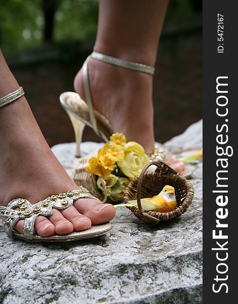 Female feet dressed in beautiful silver sandals.