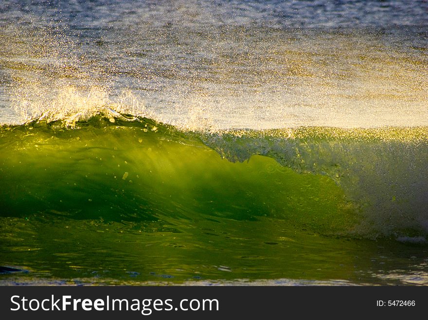 Sunlit spray from a green wave on the Atlantic ocean off the west coast of South Africa. Sunlit spray from a green wave on the Atlantic ocean off the west coast of South Africa.