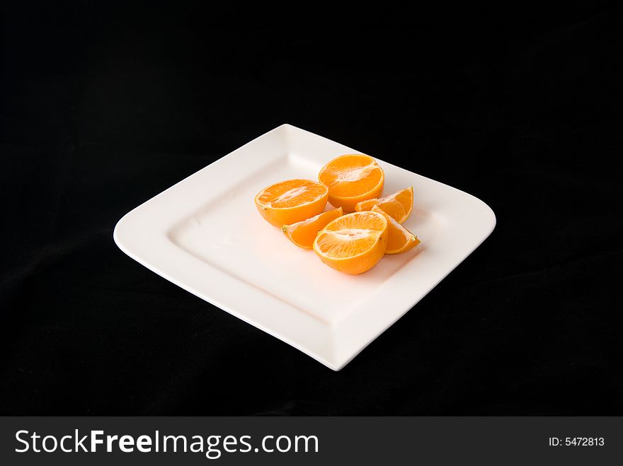 A plate of fresh orange in black background