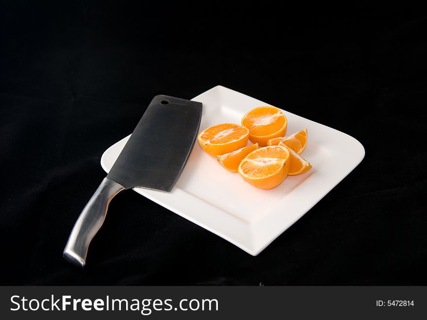 A sharp knife cuts serveral oranges into pieces. A sharp knife cuts serveral oranges into pieces