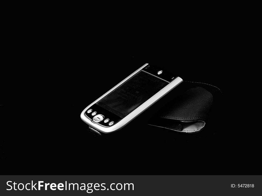 A personal digital assistant with case in black background. A personal digital assistant with case in black background.