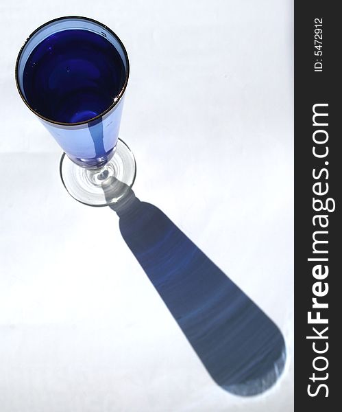 Blue glass with water on white background. Not isolated. Blue glass with water on white background. Not isolated