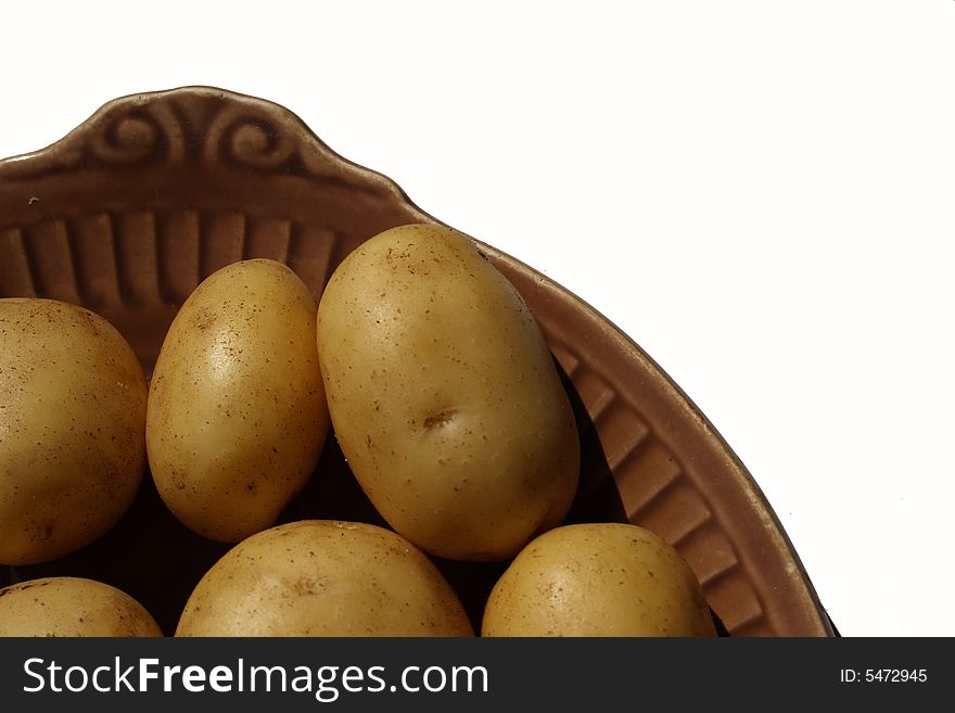 Potato on brown ceramick plate isolated on white background. Potato on brown ceramick plate isolated on white background