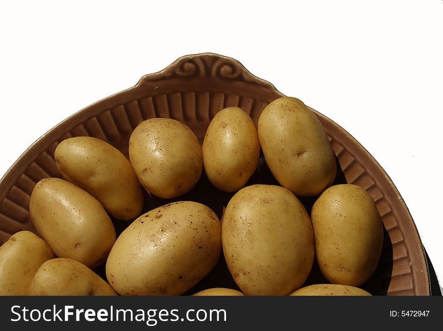 Potato on brown ceramick plate  isolated on white background. Potato on brown ceramick plate  isolated on white background