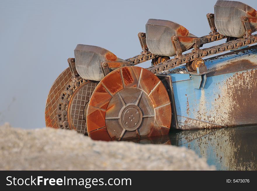 A detail vieew of a dredger in a gravel pit. A detail vieew of a dredger in a gravel pit.